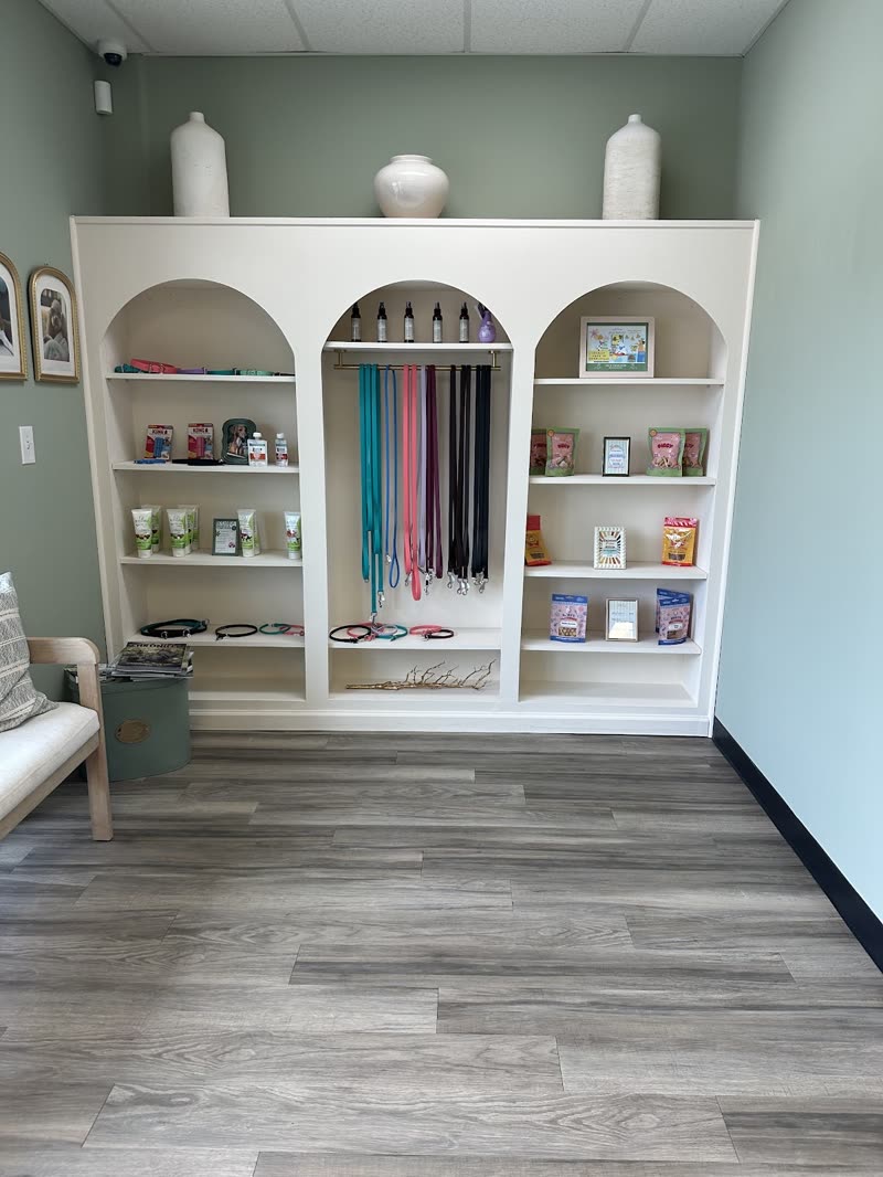 A retail corner of the salon with white arched shelving holding leads, collars and products